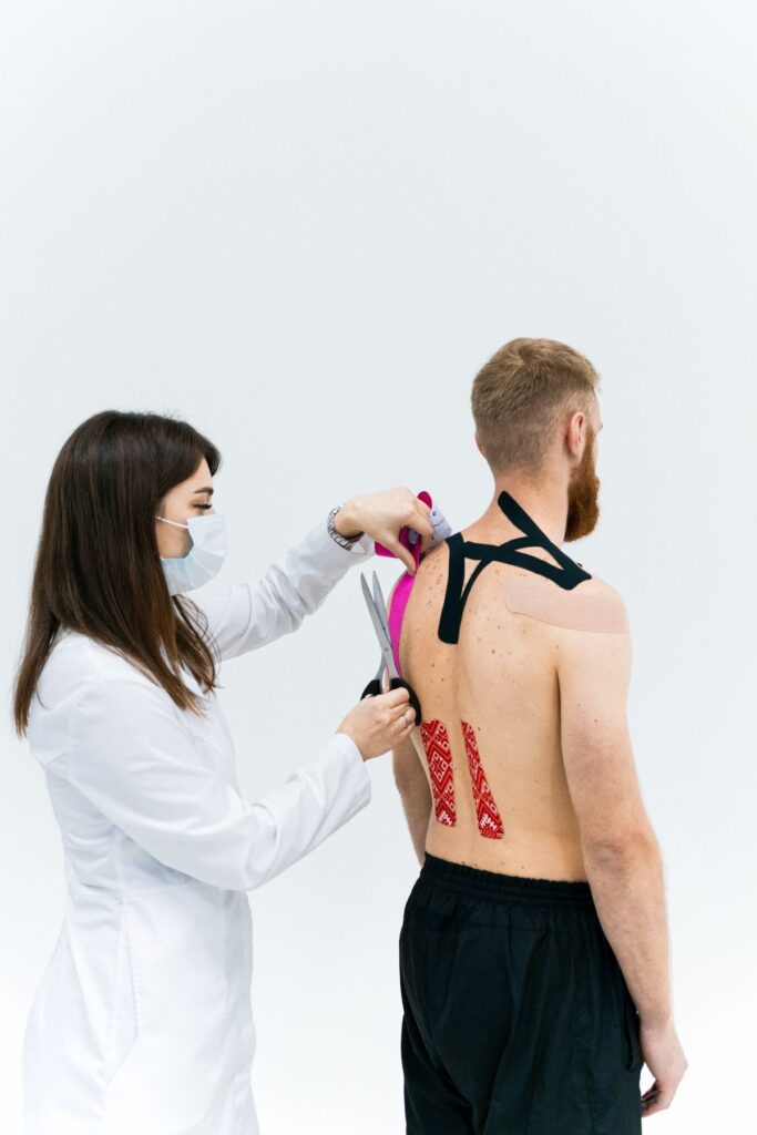 Kinesiotaping leđa - fizioterapeut aplicira traku